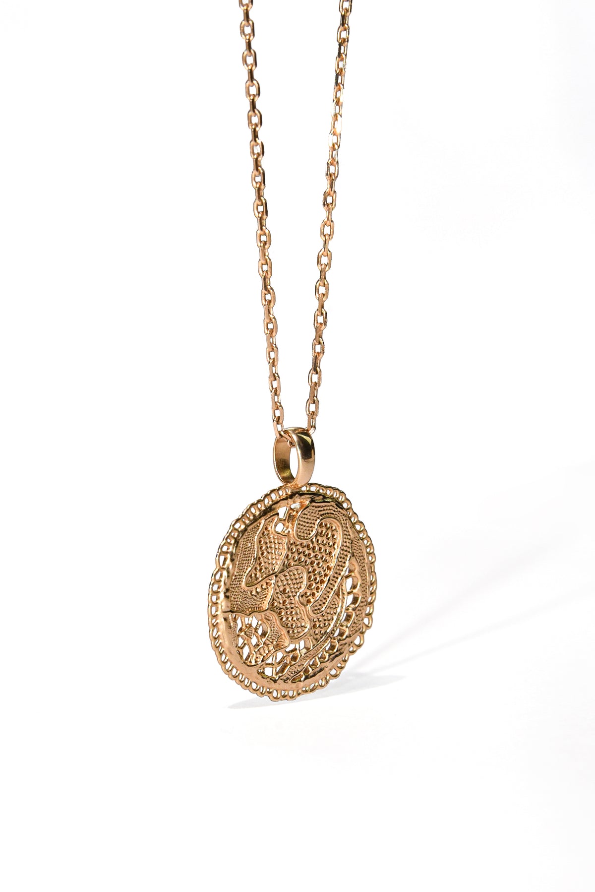 Vue de trois quarts du collier Grâce en vermeil doré à l'or 18 carats, avec médaille dentelle ajourée et chaîne fine, Maison Elise D.